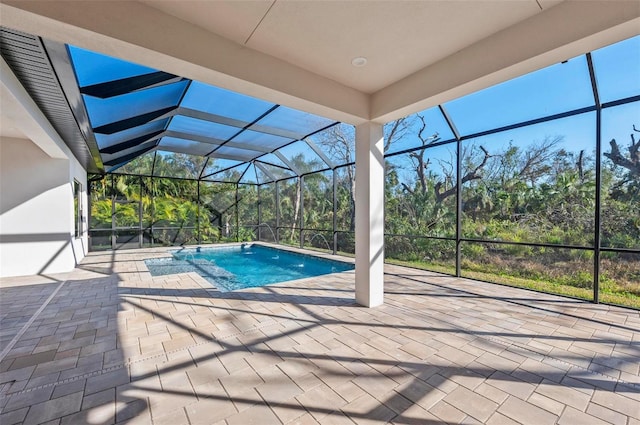 view of swimming pool featuring glass enclosure, pool water feature, and a patio