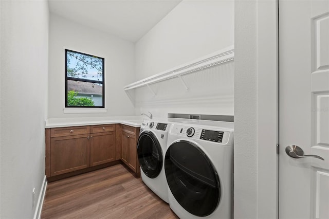 11323 Rivers Bluff Cir, Lakewood Ranch, FL 34202 - laundry room featuring washer and clothes dryer, light wood-style floors, cabinet space, and a sink