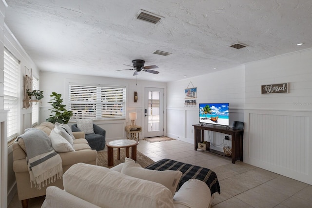 living room with light tile patterned flooring, a wealth of natural light, and ceiling fan