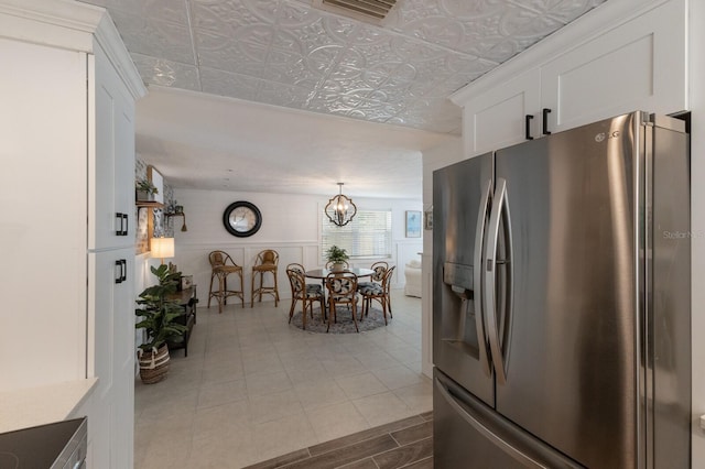 kitchen featuring white cabinetry, stainless steel refrigerator with ice dispenser, and a chandelier