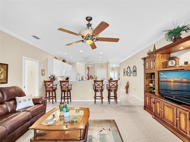 living room with ceiling fan, crown molding, and light carpet