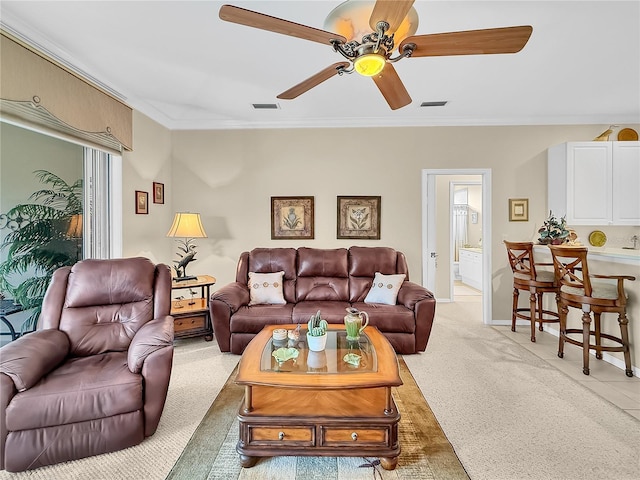 carpeted living room featuring ceiling fan and ornamental molding