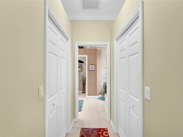 corridor with light tile patterned flooring and crown molding