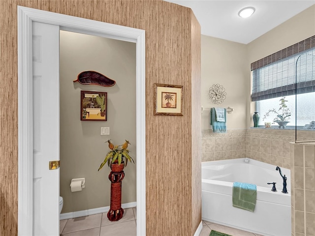 bathroom featuring toilet, a tub to relax in, and tile patterned floors