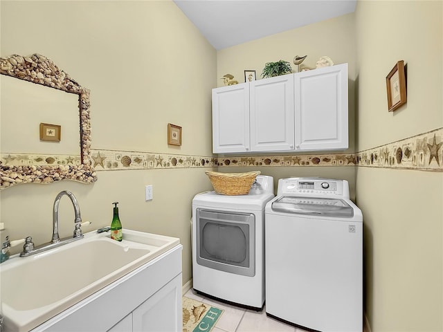 washroom with light tile patterned flooring, sink, separate washer and dryer, and cabinets