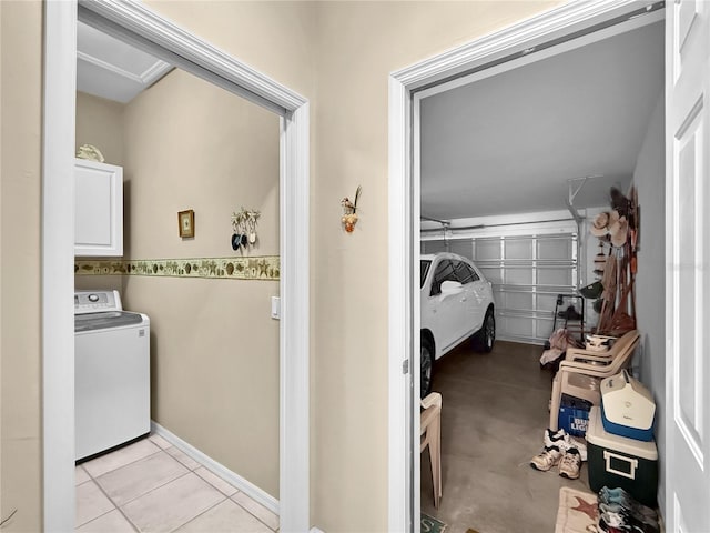 clothes washing area with light tile patterned floors, washer / dryer, and cabinets