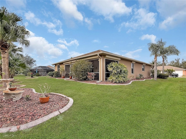 rear view of house featuring a lanai and a yard