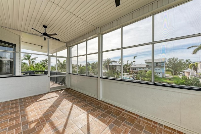 unfurnished sunroom featuring ceiling fan