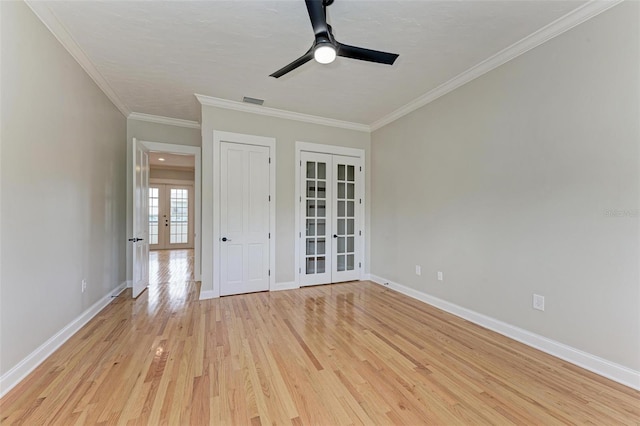 spare room with ornamental molding, ceiling fan, french doors, and light hardwood / wood-style flooring