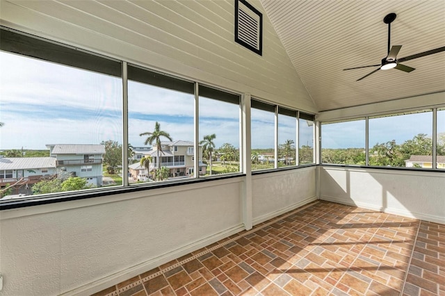 unfurnished sunroom featuring lofted ceiling, ceiling fan, and a healthy amount of sunlight