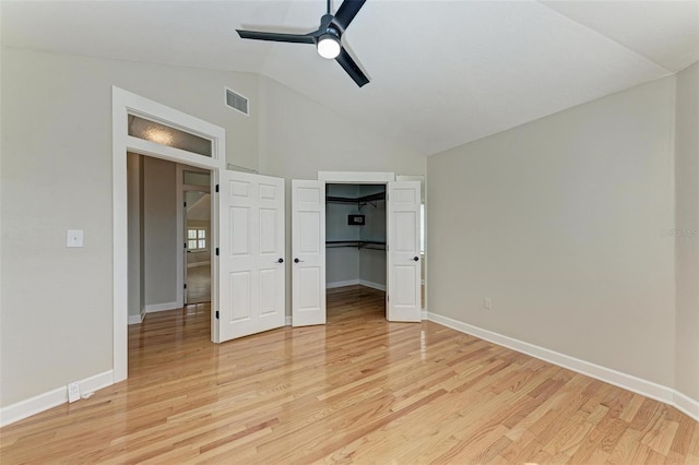 unfurnished bedroom featuring lofted ceiling, a closet, ceiling fan, and light wood-type flooring