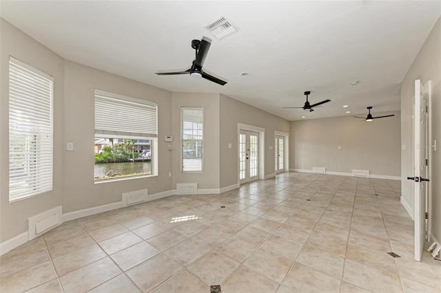 unfurnished room with ceiling fan, light tile patterned flooring, visible vents, baseboards, and french doors