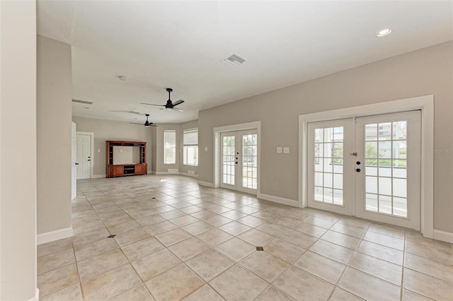 unfurnished living room with french doors, light tile patterned flooring, visible vents, and baseboards