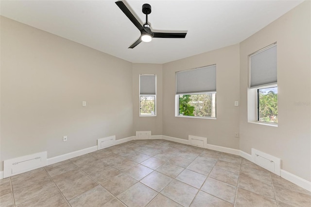 spare room featuring a ceiling fan, light tile patterned flooring, visible vents, and baseboards