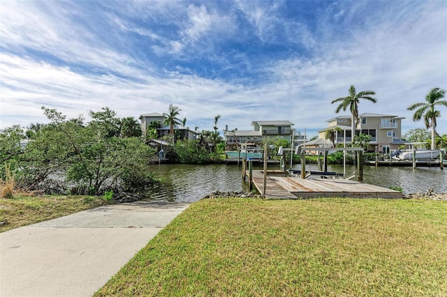 view of dock featuring a yard, a water view, and boat lift