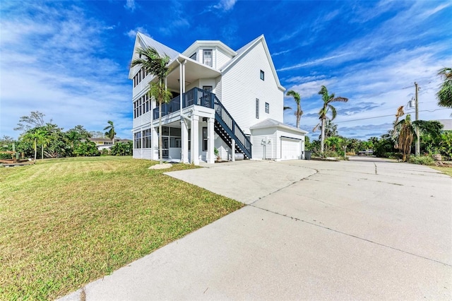 view of side of property with a lawn, a balcony, a sunroom, and a garage