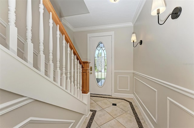 tiled foyer featuring ornamental molding, a wainscoted wall, a decorative wall, and stairway