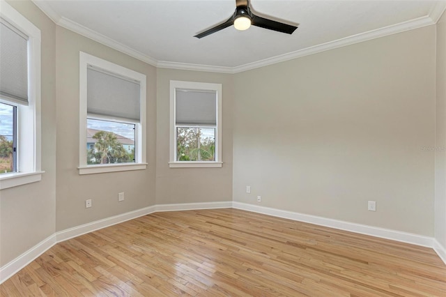 spare room featuring ornamental molding, baseboards, light wood finished floors, and a ceiling fan