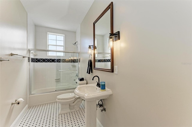 full bath with enclosed tub / shower combo, baseboards, and toilet