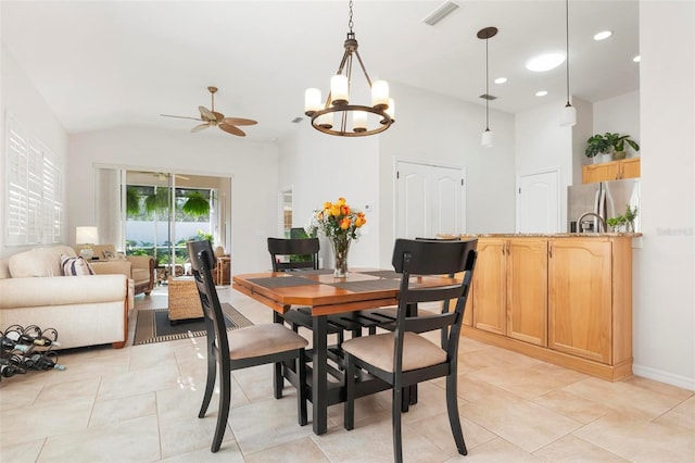 dining space featuring ceiling fan with notable chandelier, light tile patterned floors, and vaulted ceiling