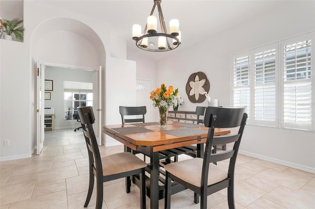 dining area with light tile patterned flooring and a notable chandelier