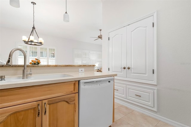 kitchen featuring sink, light tile patterned floors, ceiling fan with notable chandelier, white dishwasher, and pendant lighting