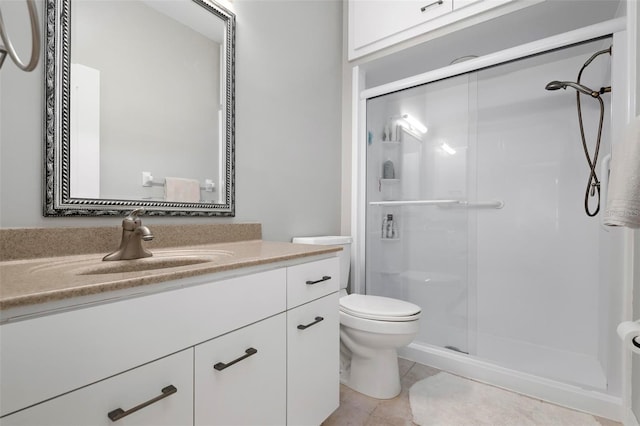 bathroom featuring toilet, tile patterned flooring, a shower with shower door, and vanity