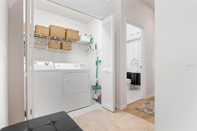 laundry room with washer and dryer and light tile patterned floors