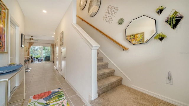 stairway featuring tile patterned flooring and ceiling fan