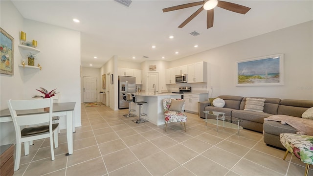 tiled living room featuring ceiling fan and sink