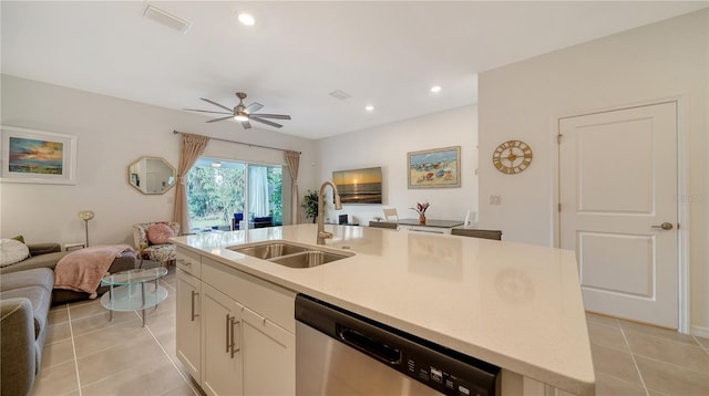 kitchen featuring dishwasher, white cabinetry, a kitchen island with sink, light tile patterned floors, and sink