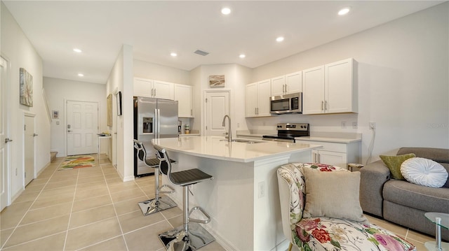 kitchen with sink, a center island with sink, white cabinets, and appliances with stainless steel finishes