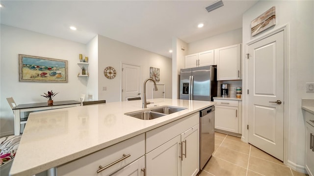 kitchen featuring light tile patterned floors, sink, white cabinets, and appliances with stainless steel finishes