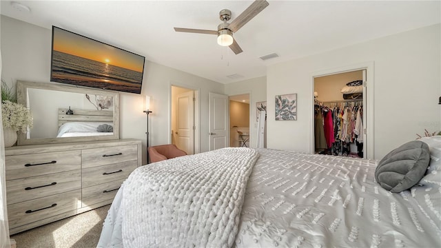 carpeted bedroom featuring ceiling fan, a closet, and a spacious closet