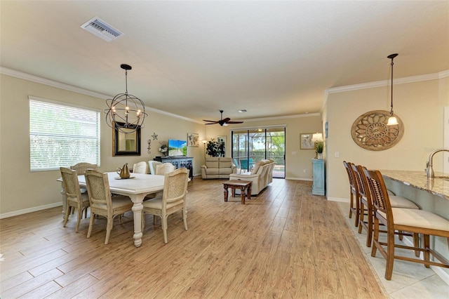 dining space with crown molding, sink, ceiling fan with notable chandelier, and light hardwood / wood-style flooring