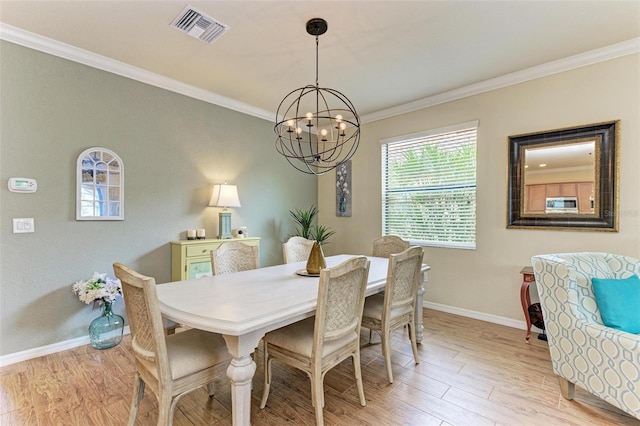 dining room with ornamental molding, a chandelier, and light wood-type flooring