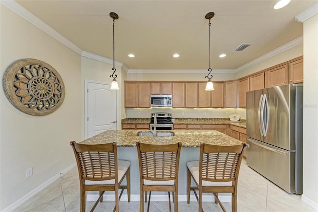 kitchen with light tile patterned floors, crown molding, appliances with stainless steel finishes, a kitchen island with sink, and hanging light fixtures