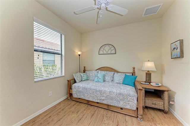 bedroom with multiple windows, ceiling fan, and light hardwood / wood-style floors