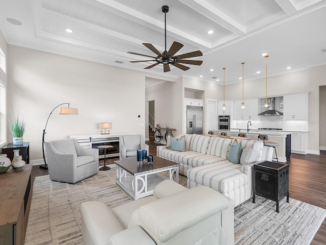 living room with beam ceiling, ceiling fan, sink, and light hardwood / wood-style flooring