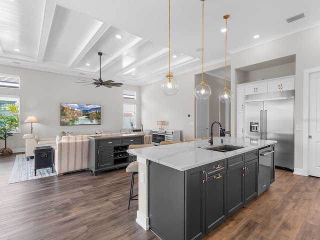 kitchen featuring white cabinets, appliances with stainless steel finishes, dark hardwood / wood-style flooring, an island with sink, and sink