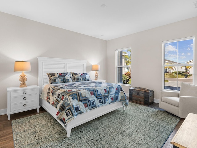 bedroom with dark wood-type flooring and multiple windows