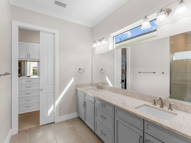 bathroom featuring walk in shower, vanity, crown molding, and tile patterned flooring