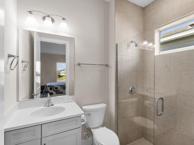 bathroom featuring a shower with shower door, vanity, and toilet