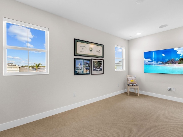 unfurnished room featuring carpet and a wealth of natural light