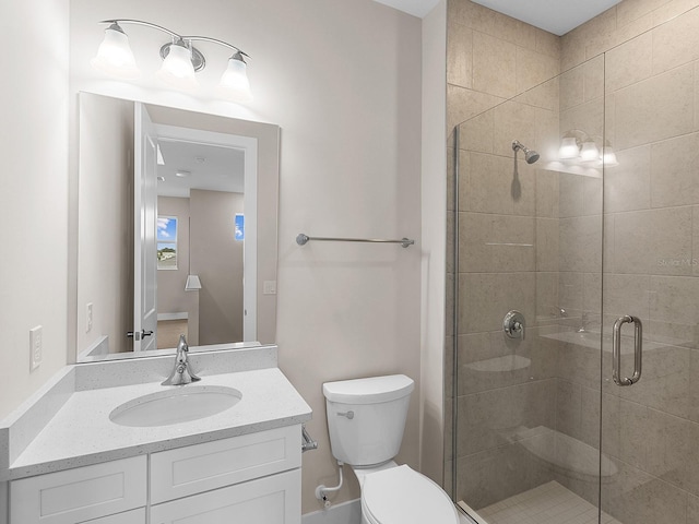 bathroom featuring an enclosed shower, vanity, and toilet