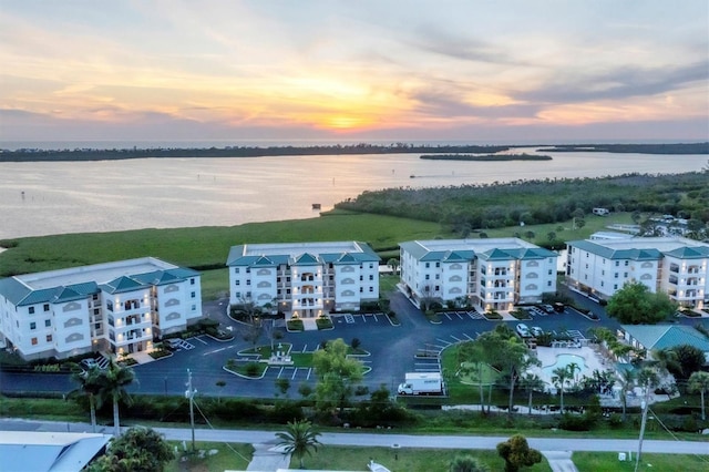 aerial view at dusk featuring a water view