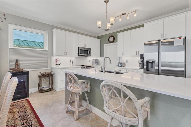 kitchen featuring hanging light fixtures, appliances with stainless steel finishes, sink, and white cabinetry