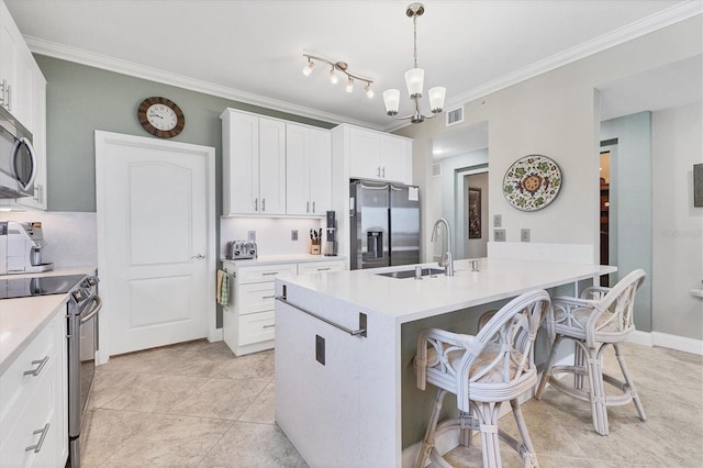 kitchen featuring sink, white cabinetry, hanging light fixtures, a kitchen island with sink, and stainless steel appliances