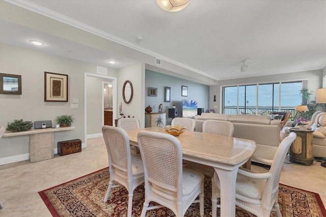 tiled dining space featuring ceiling fan and crown molding