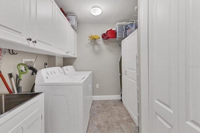 washroom featuring a textured ceiling, cabinets, and washer and dryer